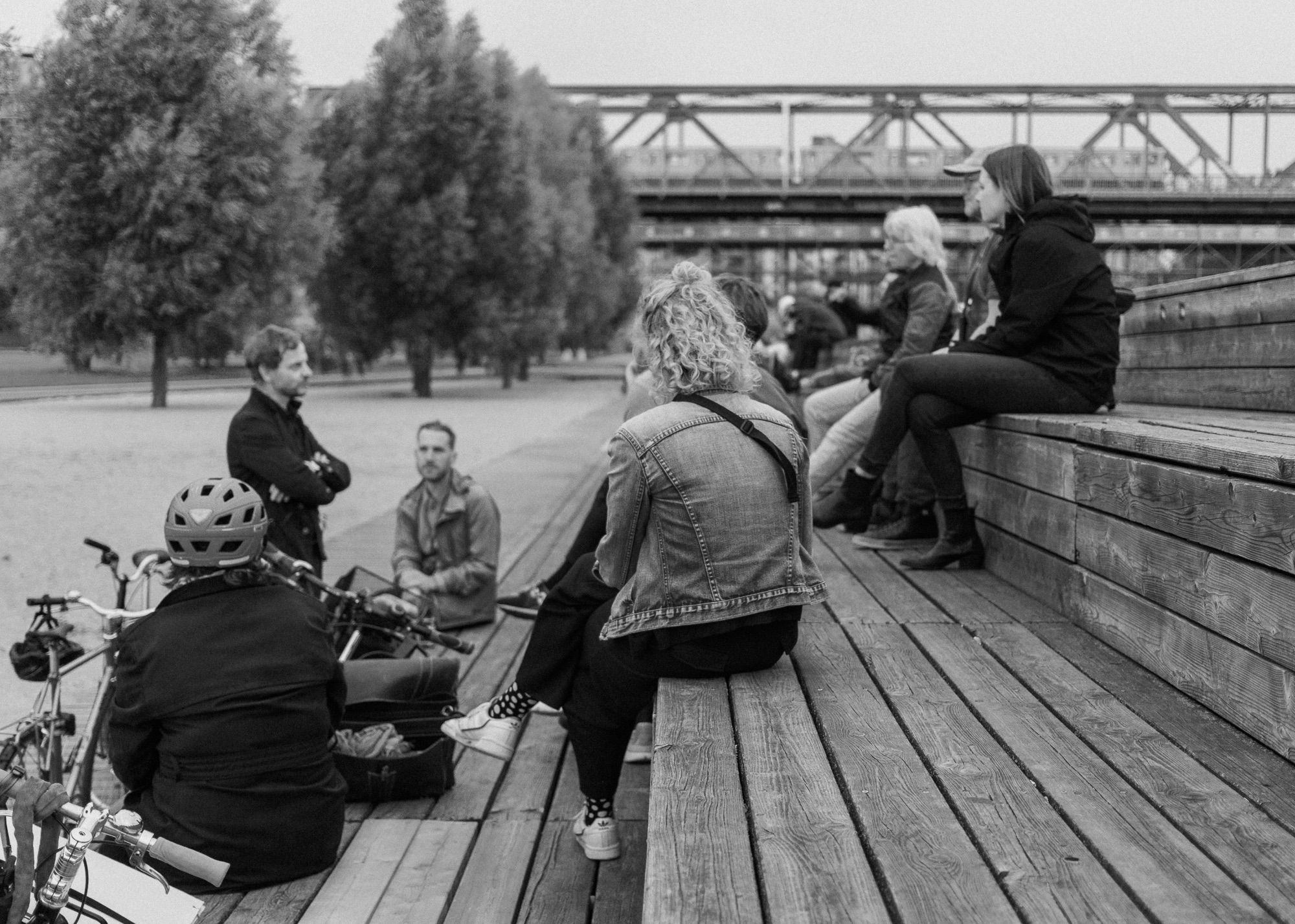 Menschen sitzen auf Stufen im Gleisdreieck-Park und reden.